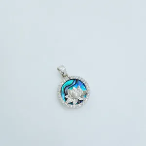 Close up detail view of the round lotus pendant with abalone shell inlay and sparkling cubic zirconia.