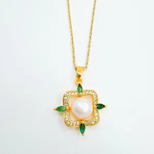 Nahaufnahme einer luxuriösen goldenen Halskette mit Perle und grünen Edelsteinakzenten.