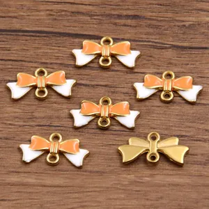 Gold enamel bow connector detail, double loop charm, DIY jewelry making accessory parts close up