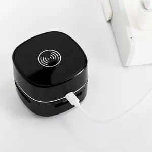 Mini aspirapolvere da tavolo portatile e caricabatterie wireless per una scrivania pulita.