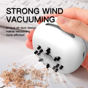 Handheld mini desktop vacuum cleaner in white with cleaning bristles for desk debris cleanup