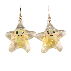 Vue détaillée de boucles d'oreilles étoile de mer en résine transparente avec des paillettes.