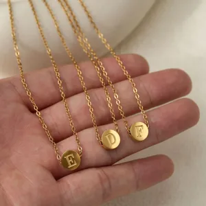 Vue détaillée d'un collier ras du cou minimaliste en acier titane doré avec pendentif lettre.