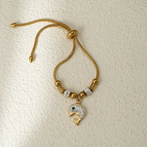 Brazalete ajustable de acero inoxidable dorado con colgante de ballena de estrás, detalle.
