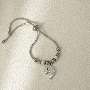 Primer plano detallado de una pulsera deslizante plateada con colgante de ballena y cadena.
