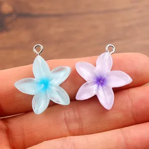 Resin flower pendant detail view, translucent five-petal floral charms with metal loop.