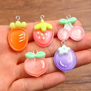 Detailed view of assorted DIY resin fruit charms with cute carrot and strawberry designs.