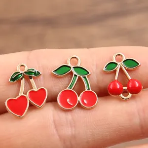 Close-up details of gold-plated enamel cherry charms, DIY alloy jewelry making pendants.