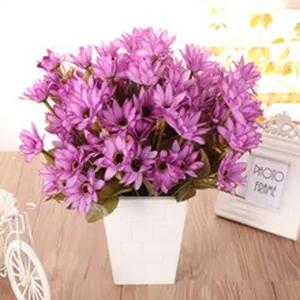 Vista dettagliata di un mazzo di fiori artificiali in seta viola in vaso quadrato bianco.