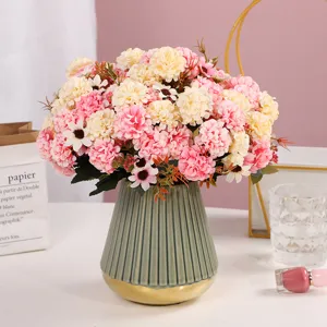 Primo piano dettagliato di fiori artificiali in vaso di ceramica verde per decorazioni.