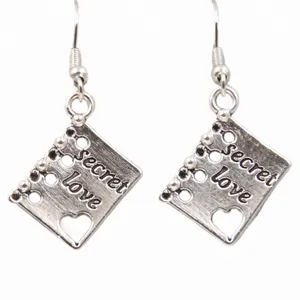 Gros plan détail des boucles d'oreilles pendentif bloc-notes en alliage de zinc.