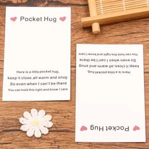 Close-up view of pocket hug greeting cards and cute white daisy patch on wood grain background.