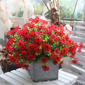 Artificial flower detail shot showing realistic red floral arrangement in a metallic pot.