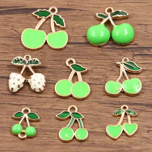 Close-up detail view of assorted alloy enamel cherry and strawberry charms for DIY jewelry making.
