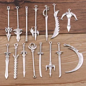 Close-up details of antique silver alloy weapon charms and miniature sword pendants for DIY crafts.