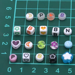 Gros plan détaillé de perles en résine acrylique colorée avec lettres et motifs pour DIY.