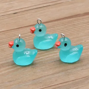 Nahaufnahme Detail von niedlichen türkisblauen Harz-Enten-Anhängern mit Metallöse und Schnabel.