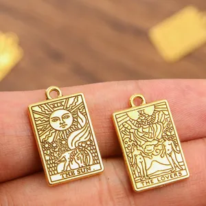 Gros plan détaillé de pendentifs en métal de carte de tarot dorés, bijoux en alliage.