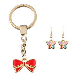 Conjunto de joyas de llavero de lazo esmaltado dorado y pendientes de mariposa coloridos.