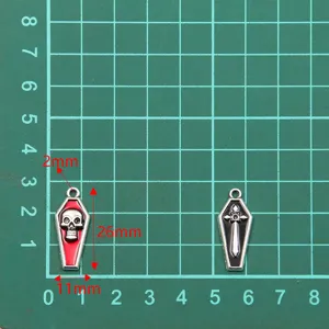 Gros plan détail de pendentifs crâne et croix en alliage rétro, dimension 11x26mm pour bijoux.