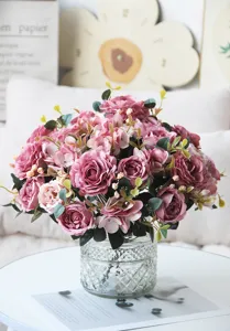 Primo piano dettagliato di un elegante bouquet di rose rosa artificiali in vaso di vetro.