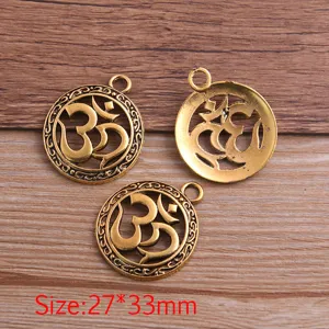 Close-up detail of vintage gold-tone metal alloy Om symbol hollow pendant for DIY craft.