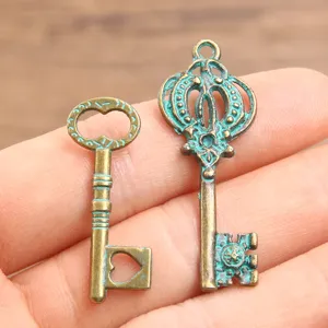 Vintage bronze alloy key charms for DIY jewelry making, hollow crown and heart pendants.