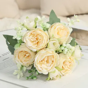Vista dettagliata di un bouquet di rose artificiali champagne con foglie per la decorazione.