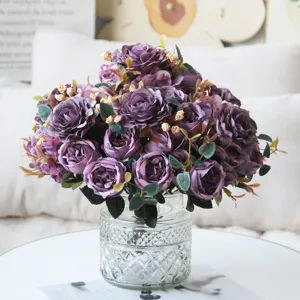 Bouquet di fiori di rose viola artificiali con vaso in vetro per decorazioni domestiche.