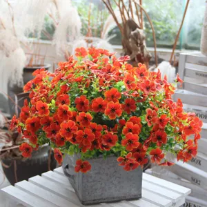 Artificial flower potted plant with vibrant orange blooms in metal pot for home decor detail.