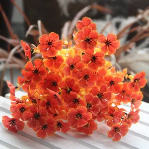 Artificial orange flower bouquet with black details for home decor, beautiful floral art prop.