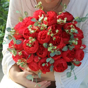 Detailed close-up of a vibrant red artificial rose bouquet with green leaves for home decor.