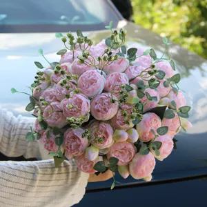 Close-up detail shot of artificial pink peony and rose bouquet for wedding decoration.