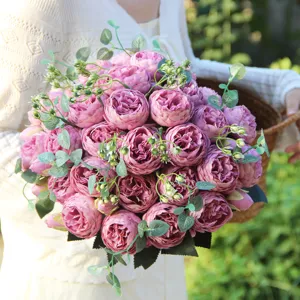 Detailed shot of artificial pink peony bouquet with green eucalyptus leaves for home decor.