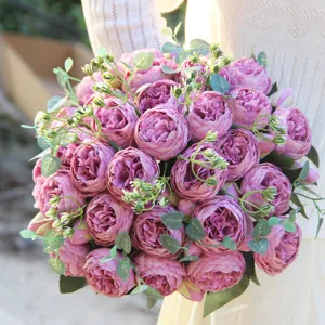 Close-up of artificial purple peony and rose bouquet with eucalyptus leaves for home decor.