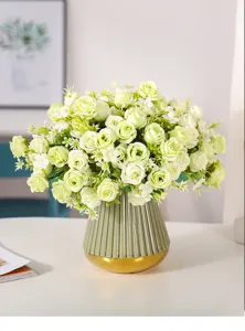 Vista dettagliata di un elegante bouquet di rose artificiali in un vaso verde per decorazione.
