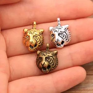 Detailed close-up view of three metal tiger head charms in gold, silver, and bronze colors.