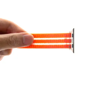 Détail de bracelet de montre en nylon orange respirant, design multi-boucles avec connecteur.