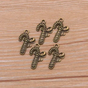 Detailed close-up view of vintage bronze candy cane bow charms, perfect for DIY jewelry making.