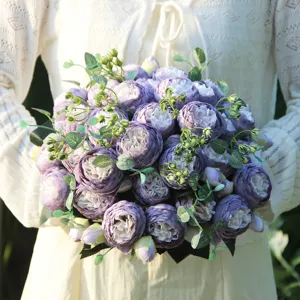 Close-up view of artificial purple peony flower bouquet with green leaves for nice home decor.
