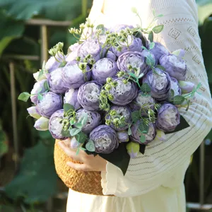 Detail view of purple artificial peony flower bouquet in a woven basket for home decor.