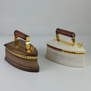 Vue détaillée de la boîte à musique bijoux fer vintage avec accents dorés et poignée bois.