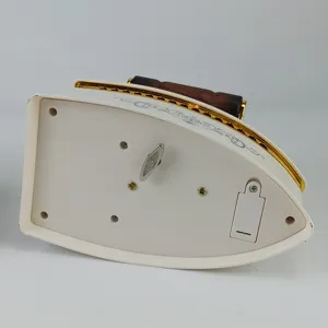 Vue détaillée d'une boîte à musique en forme de fer à repasser avec clé et design rétro.