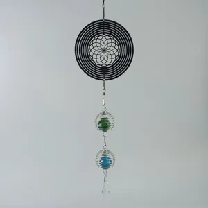 Roestvrijstalen windspinner detail met geometrisch bloemenpatroon en kleurrijke kraaltjes.