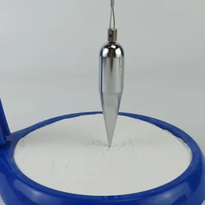 Primer plano detallado del pendulo de arena con un peso metalico sobre base azul.