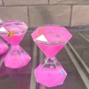 Close-up van het roze vloeibare diamant zandloper ornament van acryl met kleine vis.