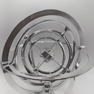 Metal orbital kinetic desk ornament detail, glossy silver finish with multi-ring rotating design.