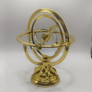 Close-up of a golden armillary sphere desktop ornament, featuring intricate metal rings.