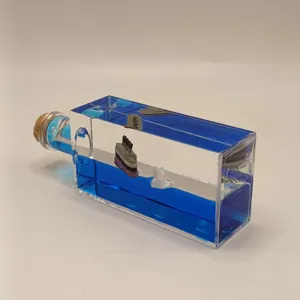 Close-up detail of the clear fluid drift bottle featuring a miniature cruise ship and iceberg.