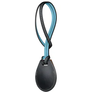 Leather airtag case detail showing black and blue contrast design with white stitching.